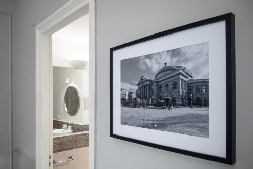 a framed picture of a building on a wall at casa mo room and suite in Palermo