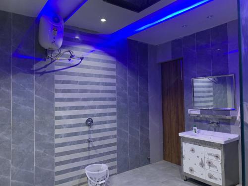 a bathroom with a sink and a shower with blue lights at Luxury 4 Bhk Villa Homestays in Patiāla