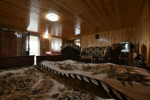 Cama grande en habitación con paredes de madera en Nika house, en Tskaltubo
