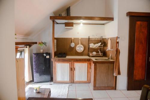 a large kitchen with wooden cabinets and aoit at Pigeon Mandala Apartments & Resto in Nusa Dua