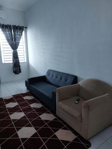 a living room with a couch and a chair at Homestay Taman Kota Emas 