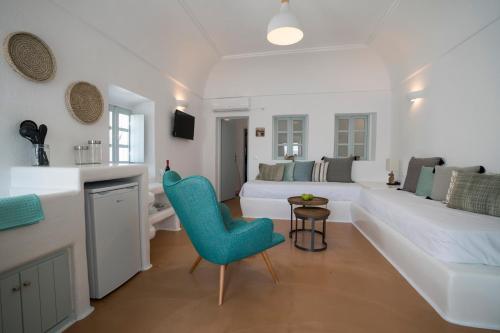 Santorini-treasures Rosemary villa traditional في Emporio: غرفة معيشة مع أريكة بيضاء وكرسي أزرق