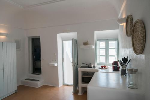 a white kitchen with a counter and a sink at Santorini-treasures Rosemary villa traditional in Emporio Santorini