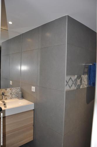 une salle de bain avec un lavabo et un miroir dans l'établissement Appartement RDJ ds villa vue mer panoramique, à Lecci