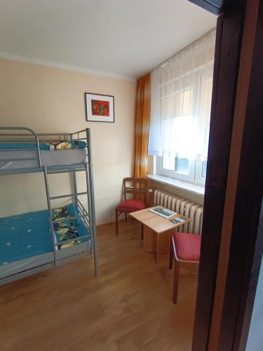 a room with two bunk beds and a table at Mieszkanie w centrum in Kłodzko