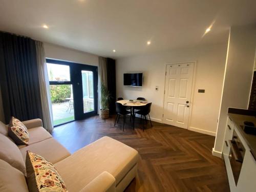 a living room with a couch and a table at The Retreat, luxury studio apartment in Bath with parking in Bath
