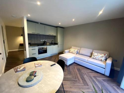 a living room with a couch and a table at The Retreat, luxury studio apartment in Bath with parking in Bath