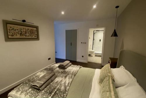 a bedroom with a bed with two towels on it at The Retreat, luxury apartment in Bath with parking in Bath