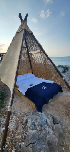 a hammock on a rocky beach with the ocean at Aponisos island in Megalochori
