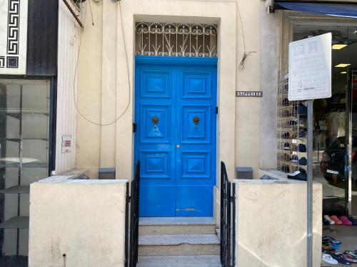 une porte bleue sur le côté du bâtiment dans l'établissement Sapphire Residences - Apartments & Penthouse In Central Sliema By Shortletsmalta, à Sliema