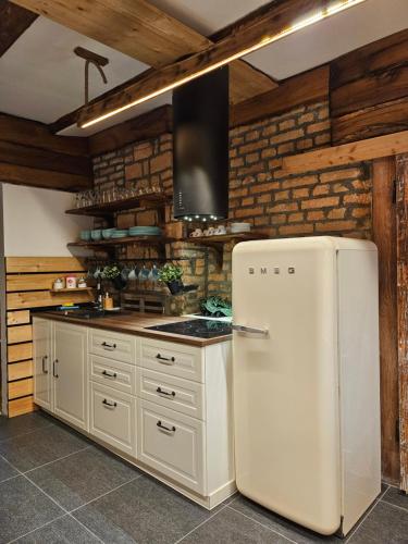 um frigorífico branco numa cozinha com paredes de madeira em Hiša stare mame em Kamnik