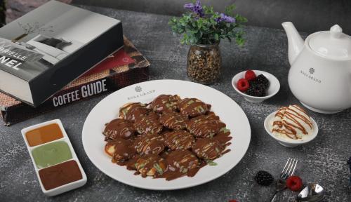 a plate of chocolate covered desserts on a table at Rosa Grand Hotel in Riyadh