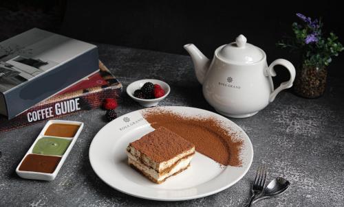 a plate of food with a piece of cake on a table at Rosa Grand Hotel in Riyadh