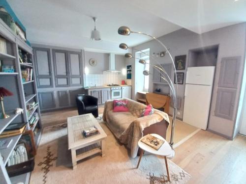 un salon avec un canapé et une table dans l'établissement Les volets bleus, à Monflanquin