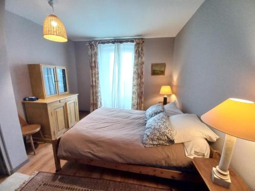 une chambre avec un grand lit et une fenêtre dans l'établissement Les volets bleus, à Monflanquin