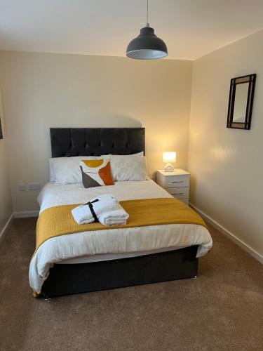 a bedroom with a large bed with towels on it at Soweway Coventry in Coventry