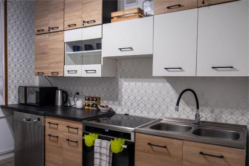 a kitchen with white cabinets and a sink at CityOasis Apartment in Nowe Miasto Lubawskie