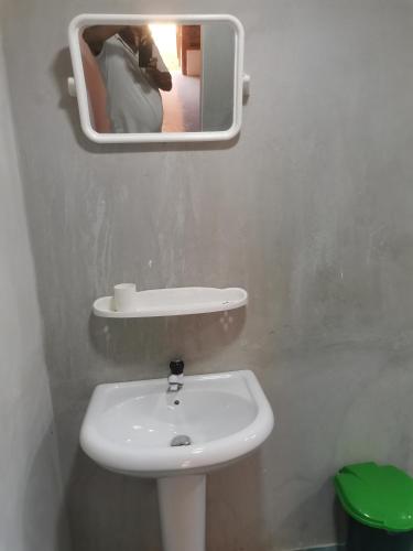 a person taking a picture of a bathroom with a sink at Bashi eco beach cabana in Trincomalee