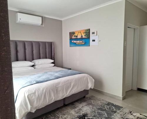 Magomba的住宿－Tree Tops Game Resort，卧室配有一张床,墙上挂着一幅画