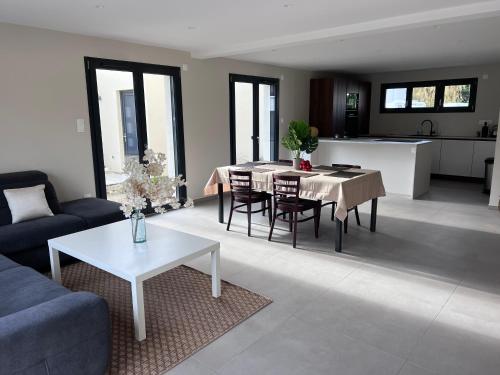 un salon avec une table et une cuisine dans l'établissement Maison harmonie, à Colmar