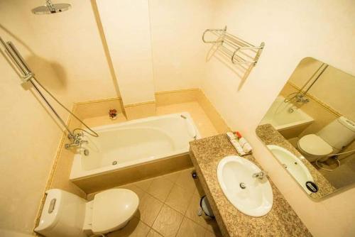 y baño con bañera, aseo y lavamanos. en Soubundith Hotel en Pakse