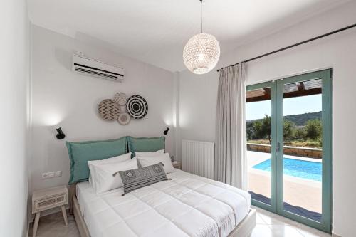 um quarto branco com uma cama e uma piscina em Maison d'Olivier em Gerani
