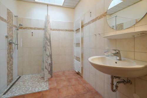 a bathroom with a sink and a shower at J. Apfeld Ferienwohnungen in Borkum