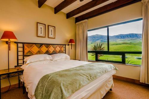 ein Schlafzimmer mit einem Bett und einem großen Fenster in der Unterkunft aha Alpine Heath Resort in Bergville
