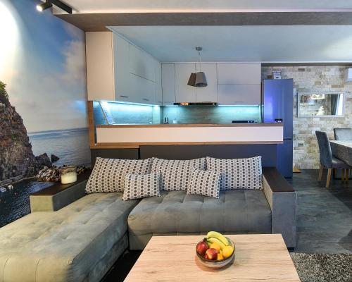 una sala de estar con sofá y un bol de fruta en una mesa en Апартамент Девио en Ruse