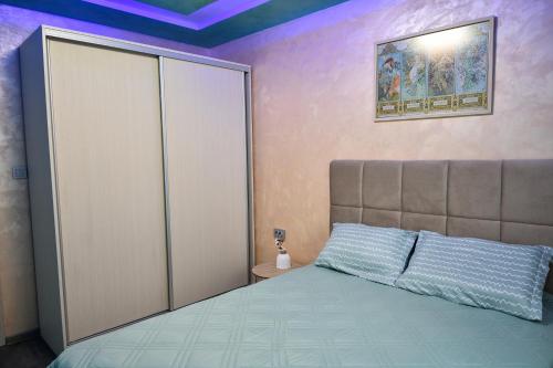 a bedroom with a bed and a large closet at Апартамент Девио in Ruse