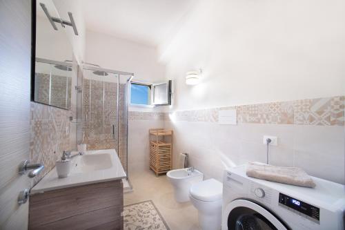 uma casa de banho com um lavatório e uma máquina de lavar roupa em Orosei mare em Orosei