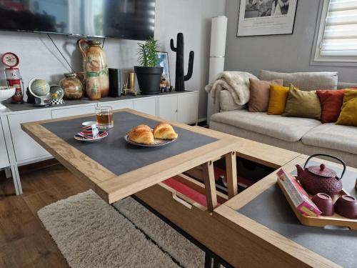 - un salon avec une table basse et du pain dans l'établissement Le Victoria - Confort, au Havre