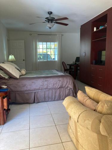 a bedroom with a bed and a couch at Hotel y villas palma Real . in La Ceiba