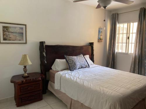 a bedroom with a bed and a table with a lamp at Hotel y villas palma Real . in La Ceiba