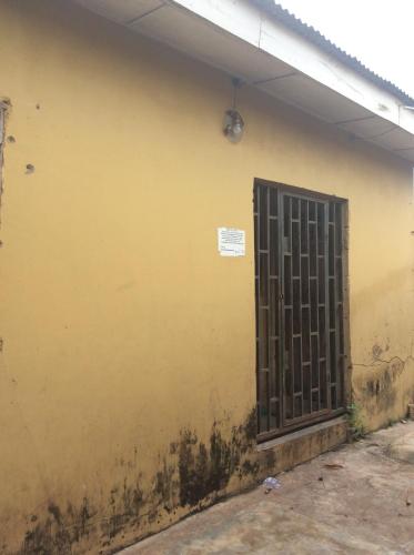 a yellow wall with a door and a gate at Charimide properties in Apena