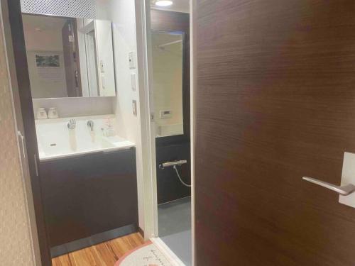 a bathroom with a sink and a door with a mirror at 駅徒歩5分！快適で贅沢、理想的なゲストルーム in Tokyo