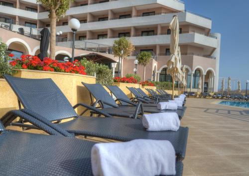 a row of chairs sitting in front of a building at Radisson Blu Resort, Malta St. Julian's in St Julian's