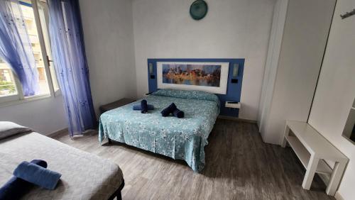 a bedroom with a bed with a blue bedspread at IDEA in Alghero