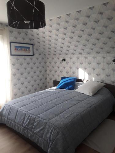 een slaapkamer met een groot bed met een grijs dekbed bij Chambres chez l habitant periode 6 juin 2024 in Bénouville