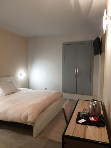 a bedroom with a bed and a table and a cabinet at Piccolo Hotel Olina in Orta San Giulio