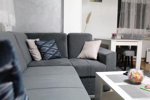 a living room with a gray couch and a table at Apartman 19 in Pale