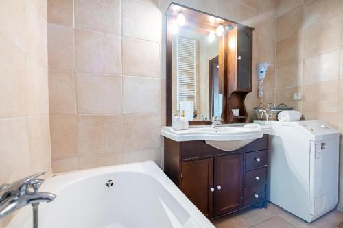 a bathroom with a tub and a sink and a bath tub at Apartment Villa Omega in Agia Pelagia