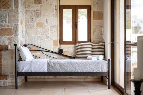 Bett in einem Zimmer neben einem Fenster in der Unterkunft Apartment Villa Omega in Agia Pelagia