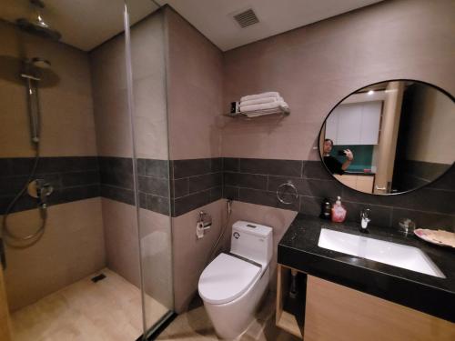 een badkamer met een toilet, een wastafel en een spiegel bij Studio view vịnh đủ tiện nghi ở Citadines Hạ Long in Ha Long