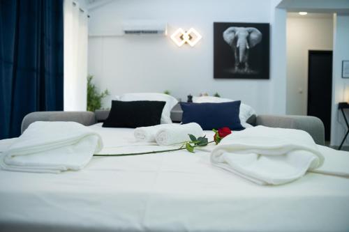 Una cama blanca con toallas encima. en L'élégance citadine en Cayenne