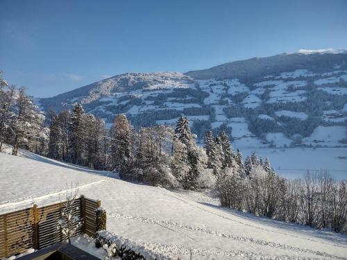 a snow covered hill with a view of a mountain at Ferienwohnung Familie Fiechtl in Fügenberg