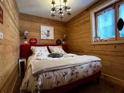 ein Schlafzimmer mit einem Bett in einem Holzzimmer in der Unterkunft Le Rocher Blanc A in Courchevel