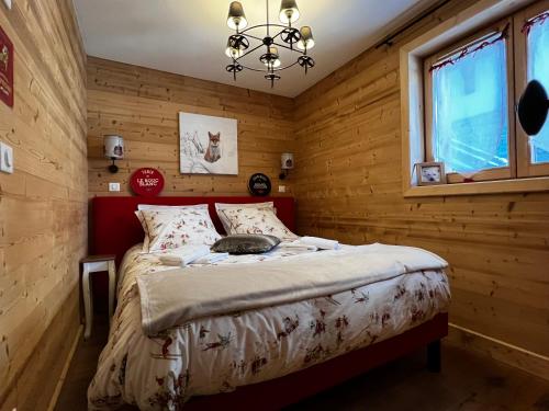 クールシュヴェルにあるLe Rocher Blanc Aの木製の部屋にベッド1台が備わるベッドルーム1室があります。