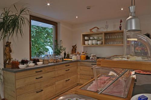 a kitchen with wooden cabinets and a large window at Gasthof Pension Alpenblick in Radfeld