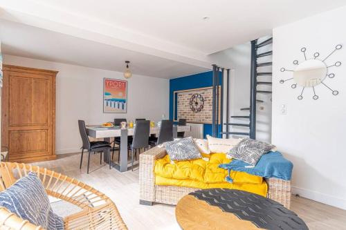 un salon avec un canapé jaune et une salle à manger dans l'établissement La Maison d’Albâtre - Plage d'Yport - 3 étoiles, à Yport